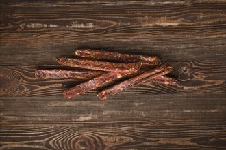 Overhead view of air dried homemade beaver sausages on wooden background