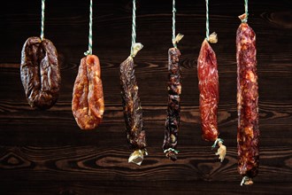 Variety of dried sausage on twine hanging in country wooden barn