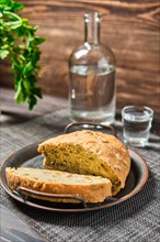Homemade bread with pumpkin seeds and frozen vodka on rustic background
