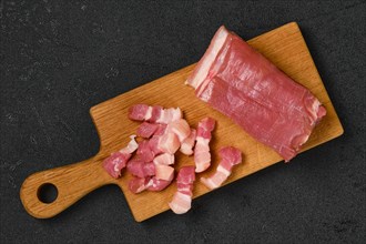Top view of raw pork belly on wooden cutting board