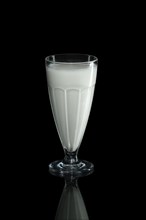 Glass of pure milk isolated on black