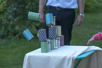 Throwing cans at a garden party