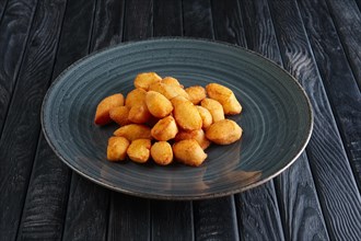 Portion of fried potato balls on dark wooden table