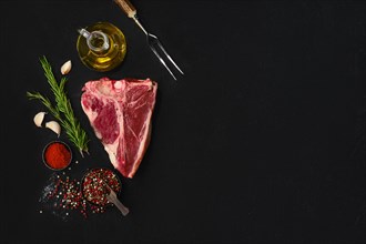 Overhead composition with raw porterhouse steak with ingredients for cooking with copy space