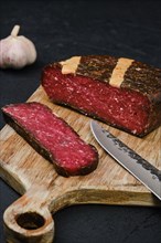 Rustic homemade cured beef ham on cutting board