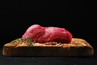 Low angle view of raw beef steak tri-tip loin on shabby wooden cutting board