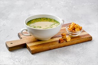 Chicken stock with croutons on wooden serving board