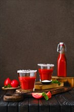 Composition with salty tomato juice on dark wooten table