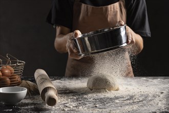 Chef dusting flour dough