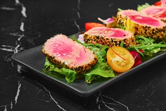 Grilled tuna steak in sesame breading with vegetables