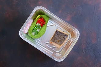 Fried salmon with pea mash decorated with radish and peas in take away packaging