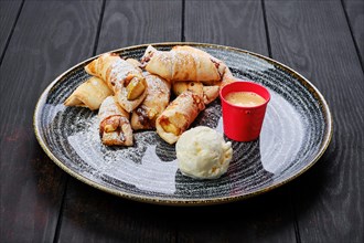Baked pear wrapped in pastry with cinnamon served with ice cream