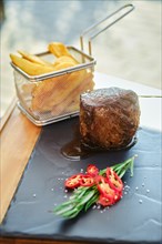 Grilled fillet mignon and french fries on slate plate