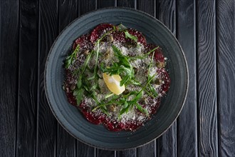 Top view of beef carpaccio with grated cheese