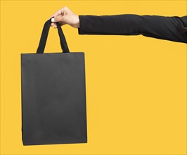 Person holding big black shopping bag copy space