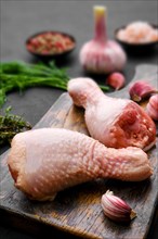 Closeup view of raw chicken legs on wooden cutting board ready for cooking