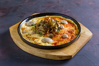Vegetarian omelette with mushrooms in cast iron pan