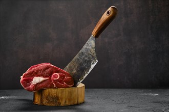 Raw fresh lamb leg and butcher cleaver