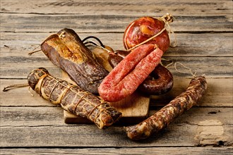 Various dried meat and sausages on wooden background