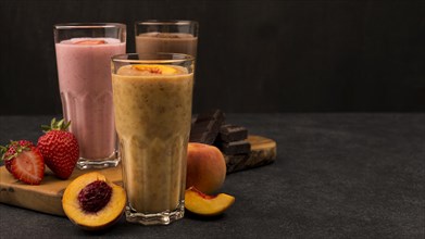 Selection three milkshake glasses with chocolate fruits