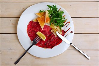 Top view of plate with beef carpaccio with cheese