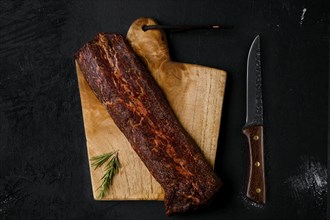 Top view of smoked beef striploin meat on cutting board