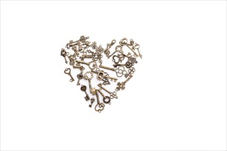 Retro metal keys form a heart shape on white