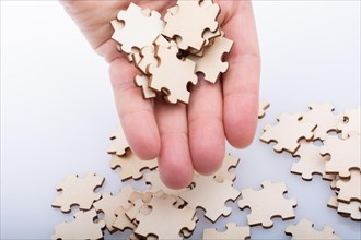 Hand holding piece of jigsaw puzzle as problem solution concept