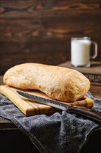 Freshly baked ciabatta on brown wooden table