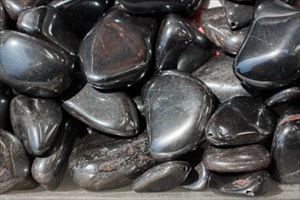 Shiny metallic gray tumbled hematite gemstone as mineral rock