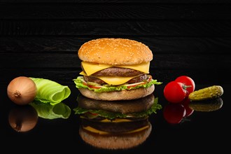 Double hamburger with some ingredients with reflection on glass