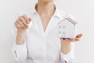 Woman holding key small paper house white background. Resolution and high quality beautiful photo
