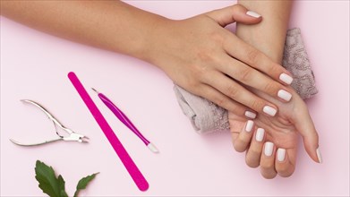Hands with manicure done and nail care tools