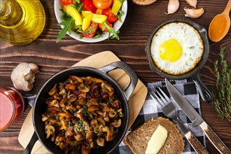 Fried mushrooms and egg in cas-iron skillet. Ingredients for rustic simple food