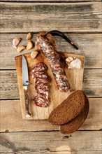 Top view of smoked dried pork sausage on wooden cutting board
