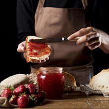 Chef spreading strawberry jam bred