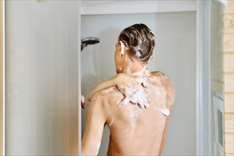 Back view of a man taking shower in cabin