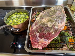 Raw leg of lamb in a roaster with vegetables and spices. Hesse