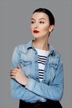 Pretty fashion model in jeans shirt with tan makeup and red mat lips
