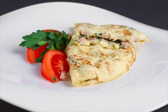 Closeup of omelet with ham and vegetables