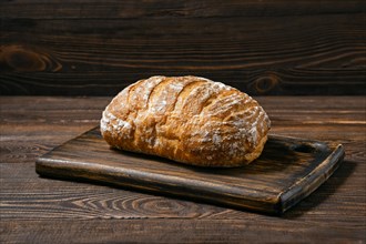 Artisan whole grain wheat bread on wooden board