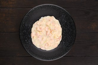 Top view of plate with ham and bacon with onion with creamy bechamel sauce