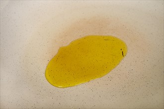 Olive oil on the surface of a frying pan