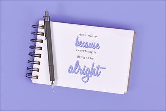Text 'Don't worry because everything will be alright' in notebook on violet background