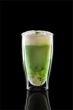 Cup of green tea matcha latte isolated on black background