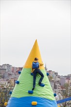 A boy climbing on cone shaped climbing course