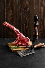 Raw prime ribeye steak on wooden cutting board