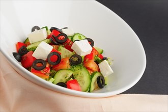 Traditional Greek salad in deep plate on table