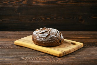 Fresh rye brown bread on wooden cutting board