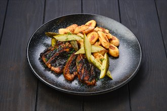 Roasted pork belly slices with pickled cucumber and gnocchi